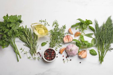 Farklı taze otlar ve baharatlar beyaz mermer masada, düz yatıyordu.