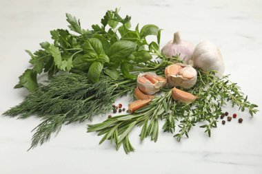 Beyaz masada farklı taze otlar ve baharatlar.