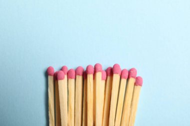 Açık mavi arka planda pembe başlıklı kibritler, üst manzara. Metin için boşluk