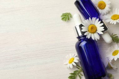 Hafif ahşap masa üzerinde gerekli yağ şişeleri ve papatya çiçekleri, düz yatıyordu. Metin için boşluk