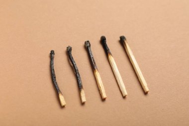 Bej arkaplanda yanmış kibritler, üst görünümde