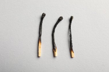 Gri arkaplanda yanmış kibritler, düz yatış