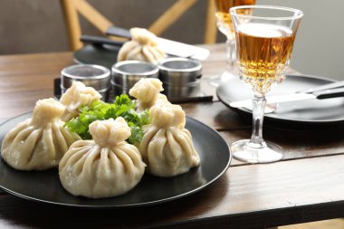 Nefis khinkali kişniş ve şarapla servis edilir ahşap masada, yakın plan.