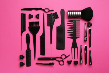 Pembe arka planda farklı kuaför aletleri, düz yatış