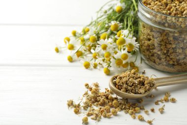 Kuru ve taze papatya çiçekleri beyaz ahşap masada, yakın plan. Metin için boşluk