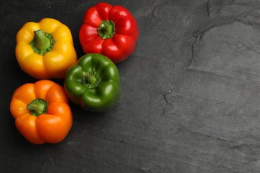 Taze renkli dolmalık biberler siyah desenli masada, düz yerde. Metin için boşluk