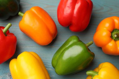 Taze renkli dolmalık biberler mavi ahşap masada, düz yatıyordu.