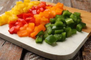 Ahşap masada renkli dolmalık biberler kes, yakın plan.