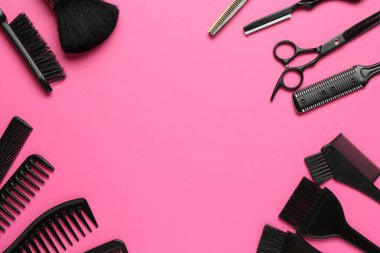 Farklı kuaför aletlerinin çerçevesi pembe arka planda, düz yerde. Metin için boşluk