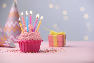 Kekin içinde mum yakmak, fıskiyeler ve bulanık ışıklara karşı masanın üstünde parti dekorasyonu. Metin için boşluk