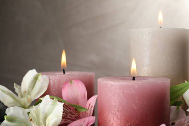 Yakıcı mumlar ve güzel çiçekler arka planda, yakın plan. Metin için boşluk