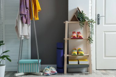 Koridorda farklı ayakkabı, giysi ve aksesuarlar var.