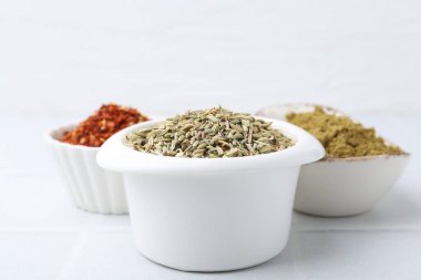 Beyaz döşeme üzerinde farklı aromatik baharatlar, yakın plan.