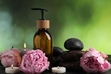 Islak taşlı spa kompozisyonu, yanan mumlar ve koyu yeşil arka planda kozmetik ürünler, yakın plan.