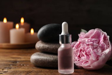 Dökücü, taş ve çiçekli spa bileşimi ahşap masa üzerinde siyah arkaplan, yakın plan