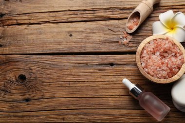 Düz kompozisyon, spa ürünleri ve çiçekli ahşap masa. Metin için boşluk