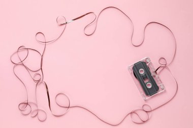 Pembe arka plandaki ses kasetindeki manyetik banttan yapılmış çerçeve, üst görünüm. Metin için boşluk