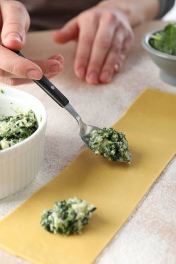 Peynirli ve ıspanaklı ravioli yapan kadın, yakın plan.