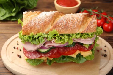 Tahta masada jambonlu ve sebzeli baget sandviç, yakın plan.
