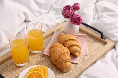 Nefis bir kahvaltı tepsisi ve çiçeklerle kapalı bir yerde, yakın plan.