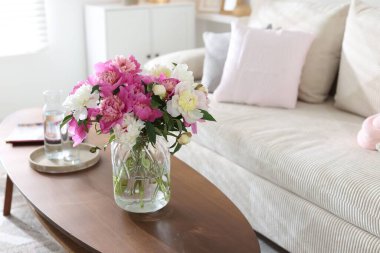 Bir buket güzel şakayık ve sehpanın üzerinde su, mesaj için yer. İç tasarım