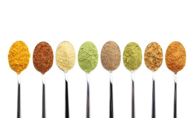 Beyaz arka planda kaşıklarda farklı süper yiyecek tozları, kolaj. Üst görünüm