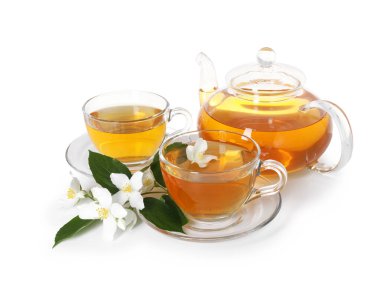 Camdan fincanlar, çaydanlık, çiçekler ve beyaz üzerine izole edilmiş yeşil yapraklar.