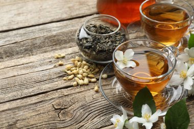 Cam bardaklarda yasemin çayı, ahşap masada bira ve çiçekler, yakın plan. Metin için boşluk