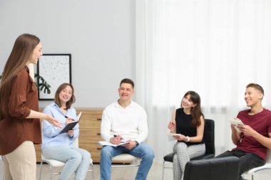 Yaşam koçluğu dersinde kapalı alanda toplantı yapan bir grup insan.