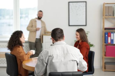 İş arkadaşları öğle arasında ofiste sohbet ediyorlar.