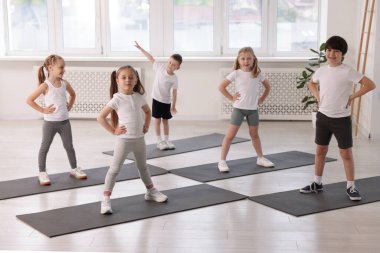 Sınıfta yoga minderleri üzerinde bir grup çocuk.