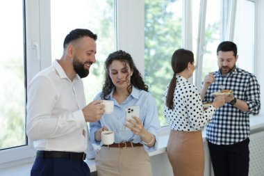 Yemek ve içeceklerle iş arkadaşları öğle arasında ofiste pencere kenarında.