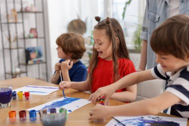 Resim dersinde öğretmenleri olan çocuklar. Çizim yapmayı öğrenmek