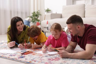 Ebeveynler çocuklarına evde yerde çizim yapmayı öğretiyor.