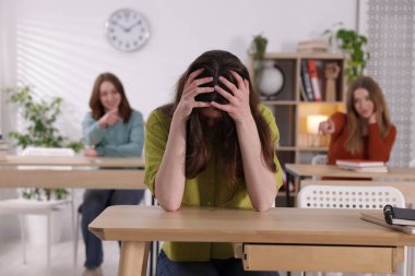 Zorbalık. Okulun masasındaki üzgün genç kız.