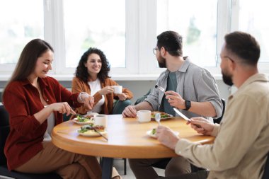 İş arkadaşları öğle arasında ofiste sohbet ediyorlar.