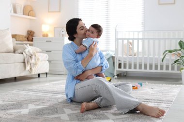 Anne evde tatlı bebeğini öpüyor.