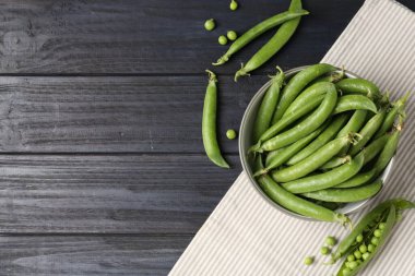 Taze taze taze bezelyeler, siyah ahşap masada, düz yerde. Metin için boşluk