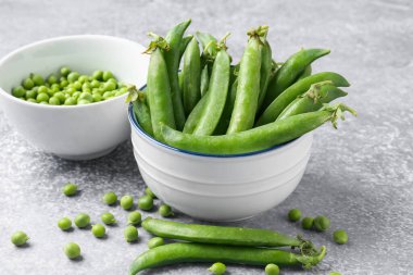 Gri masada taze taze taze bezelyeler, yakın plan.