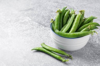 Gri masada taze taze taze bezelyeler, yakın plan. Metin için boşluk