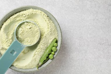 Protein tozu ve açık gri masada taze bezelyeler, üst manzara. Metin için boşluk