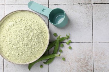 Protein tozu ve yeşil bezelyeler açık renkli masada, düz yerde. Metin için boşluk