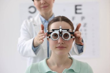 Hastanın vizyonunu klinikte deneme çerçevesiyle inceleyen oftalmolog, yakın plan.