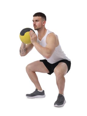 Beyaz arka planda ilaç topuyla egzersiz yapan adam.