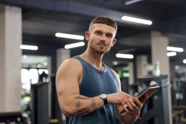 Spor merkezinde tableti olan kişisel antrenör.