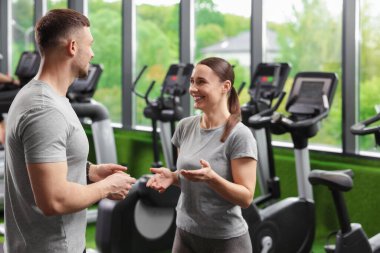 Spor merkezinde konuşan profesyonel kişisel antrenörler.