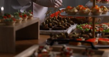 Şef açık büfe için kırmızı havyarlı sandviçler yapıyor.