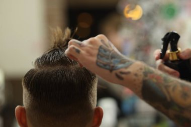 Profesyonel berber berber dükkanında şık saç kesimi yapıyor, yakın plan.