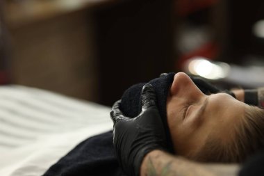 Berber dükkanında müşteriyle çalışan profesyonel berber, yakın plan. Metin için boşluk