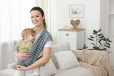 Anne çocuğunu askıda (bebek taşıyıcısı) tutuyor, mesaj için boşluk